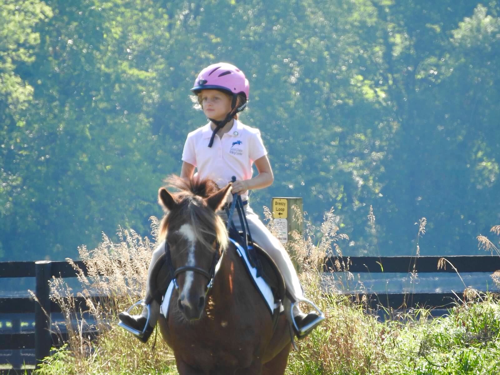 Rylen riding through tall grass on a trail